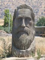 The Head of John Muir sits on Highway 198 carved out of wood.